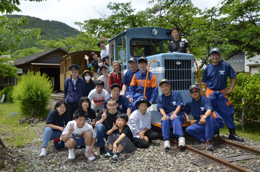 約３０年前に復元した「谷村式」の森林鉄道車両を囲む集落活動センターやなせのメンバー（馬路村魚梁瀬の丸山公園）