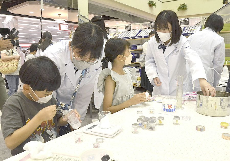 高知高専の女子学生にスノードーム作りを教わる子どもたち（南国市のサニーアクシス南国店）