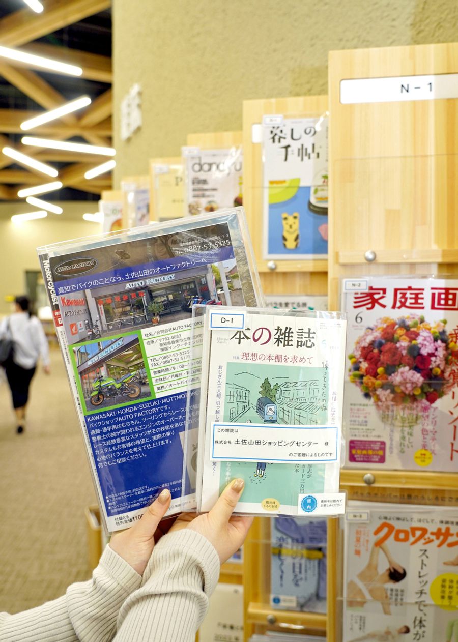 企業が購入した雑誌が並ぶ香美市立図書館「かみーる」。出資した企業名や広告が入ったカバーがかけられている（香美市土佐山田町楠目の同館）