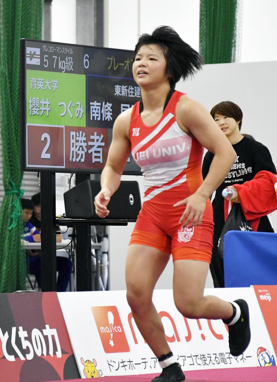 レスリングの世界選手権代表決定プレーオフで勝利し、監督らのもとへ走り寄る桜井つぐみ。ラスト１秒足らずの大逆転だった（東京都立川市のドーム立川立飛）