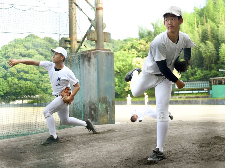 ブルペンで投球練習に励む高知商の草道(右)と井上