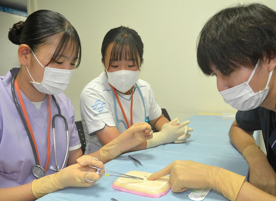 模擬皮膚への縫合手術を体験する中高生（高知市大川筋１丁目の近森病院）