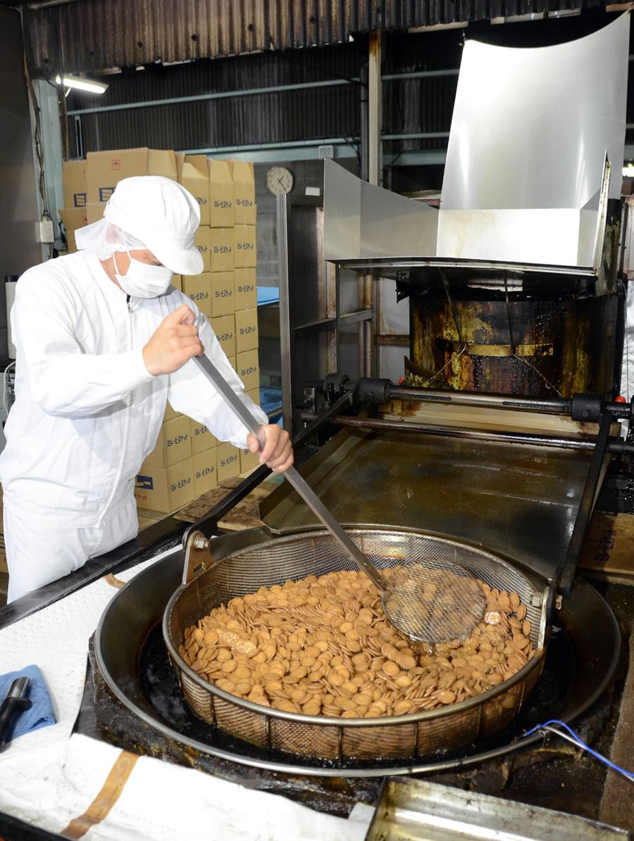 120度の油でさっと揚げるミレー。全国に出荷される看板菓子に育った(高知市大津乙)