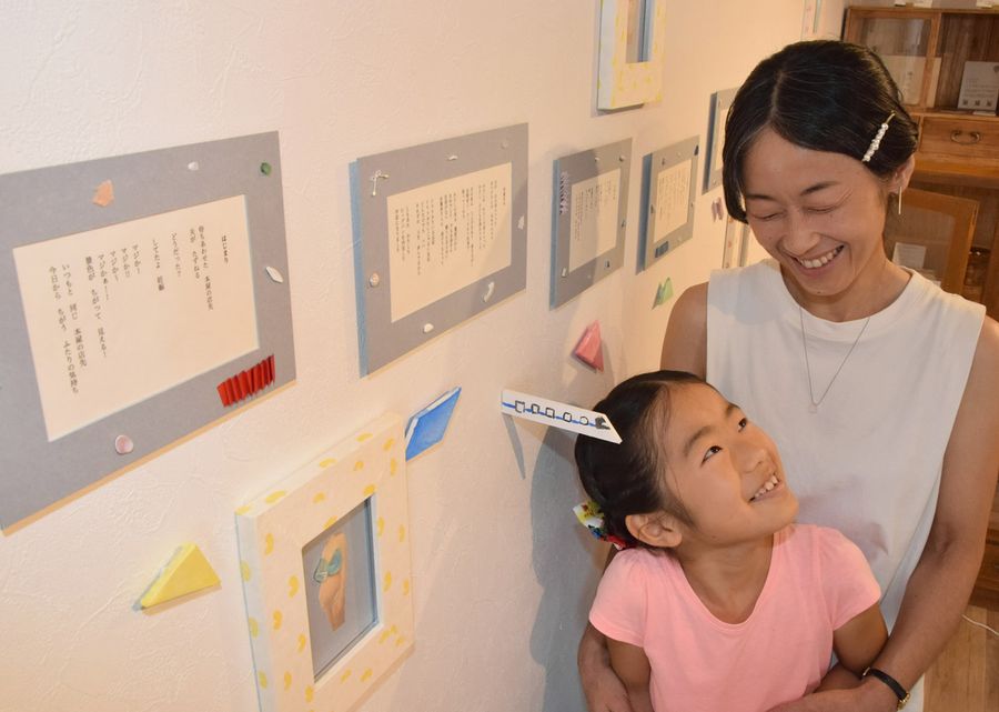 自作した詩を紹介する飯島敦子さんと長女のあわいさん（高知市桜井町１丁目）