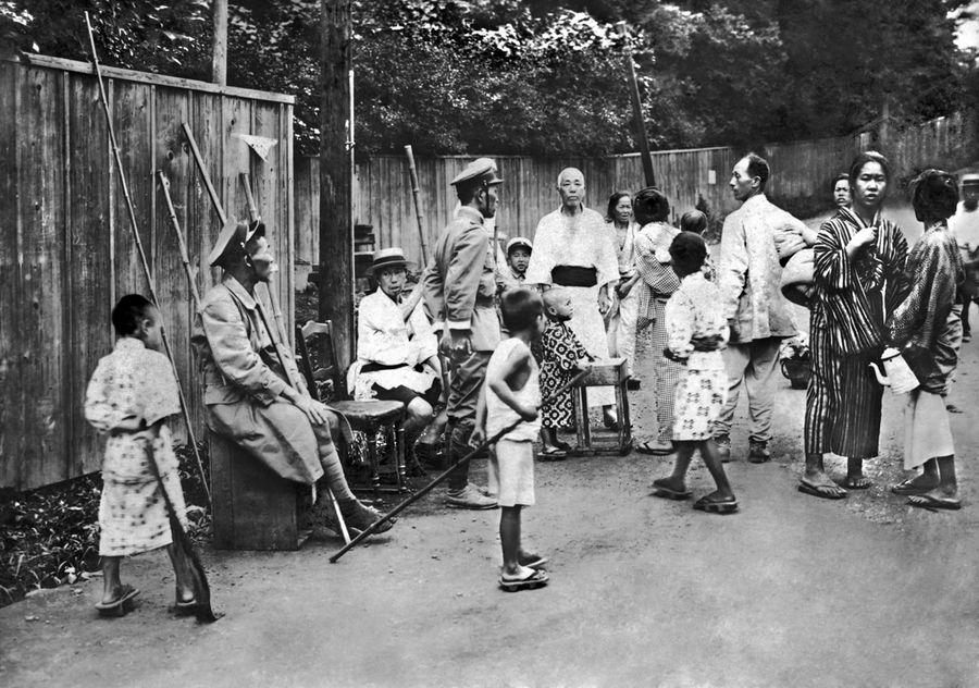 関東大震災直後、竹の棒を持って集まる人々。子どもたちの姿も見える（東京・麻布付近）