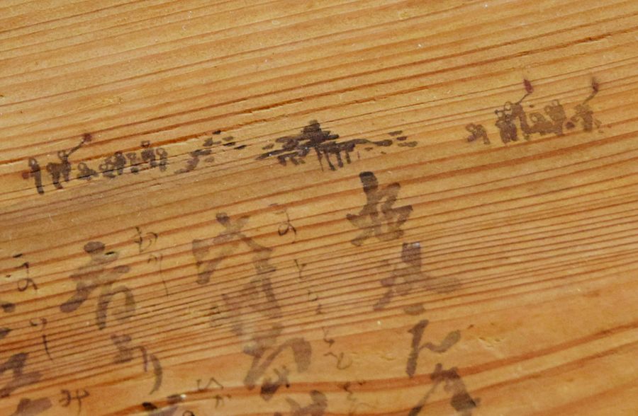 安政地震の絵馬。上部に、たいまつをたいて逃げ惑う人々が描かれている（佐川町東組の入寺山公民館）