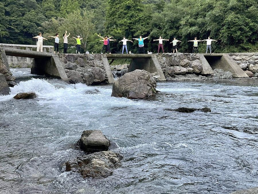 流域内外が連携して開かれた沈下橋でのヨガ体験会（２０２２年７月、高知市土佐山桑尾＝同市提供）