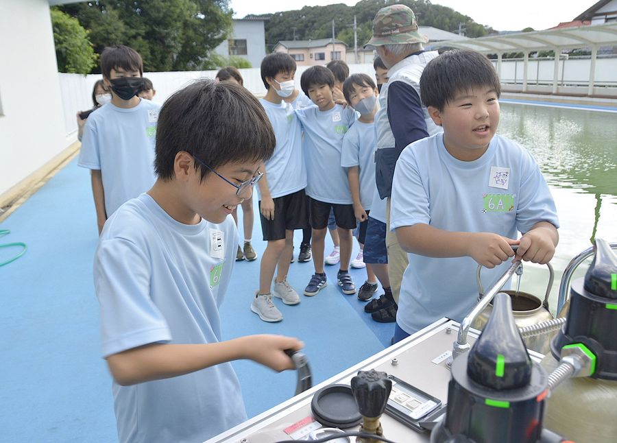 浄水機を使ってプールの水をろ過する児童たち（土佐市の蓮池小学校）