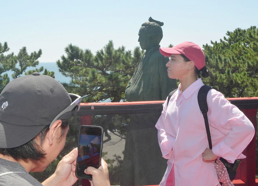 龍馬像との〝ツーショット〟を楽しむ観光客（高知市の桂浜）