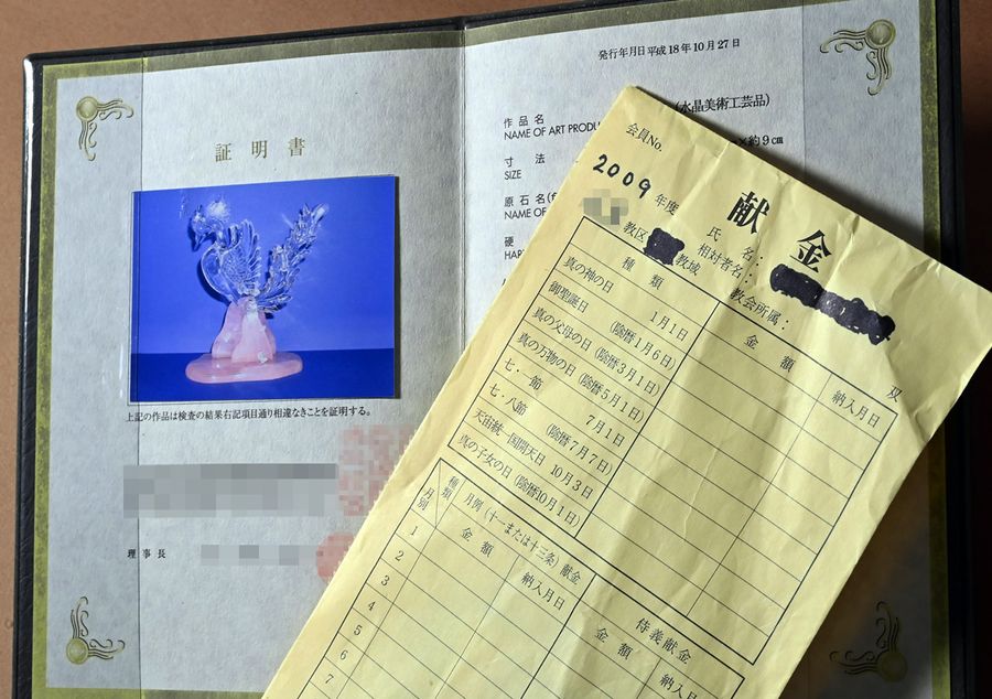 女性が３００万円で買った水晶の置物の証明書と献金袋
