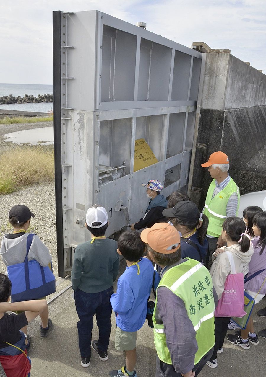 海岸堤防で陸閘の開閉作業を体験する三和小学校の児童（南国市浜改田）