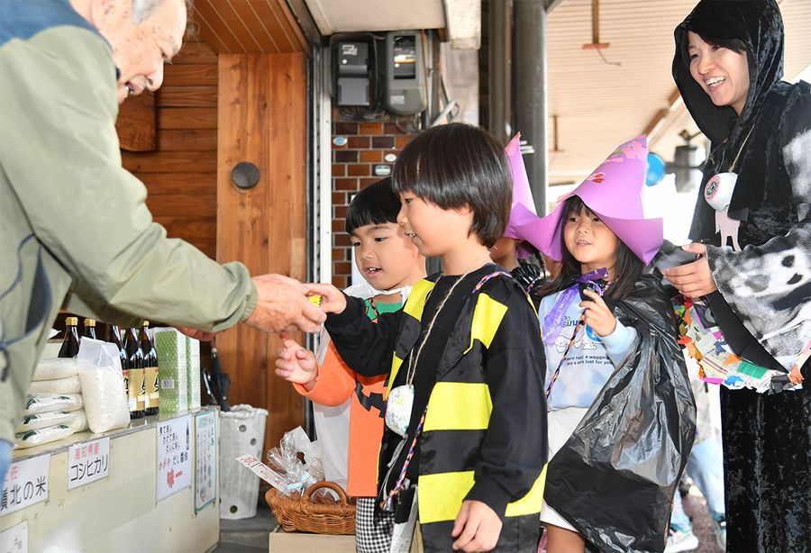 商店街の店主からお菓子をもらう園児ら（高知市の愛宕商店街）
