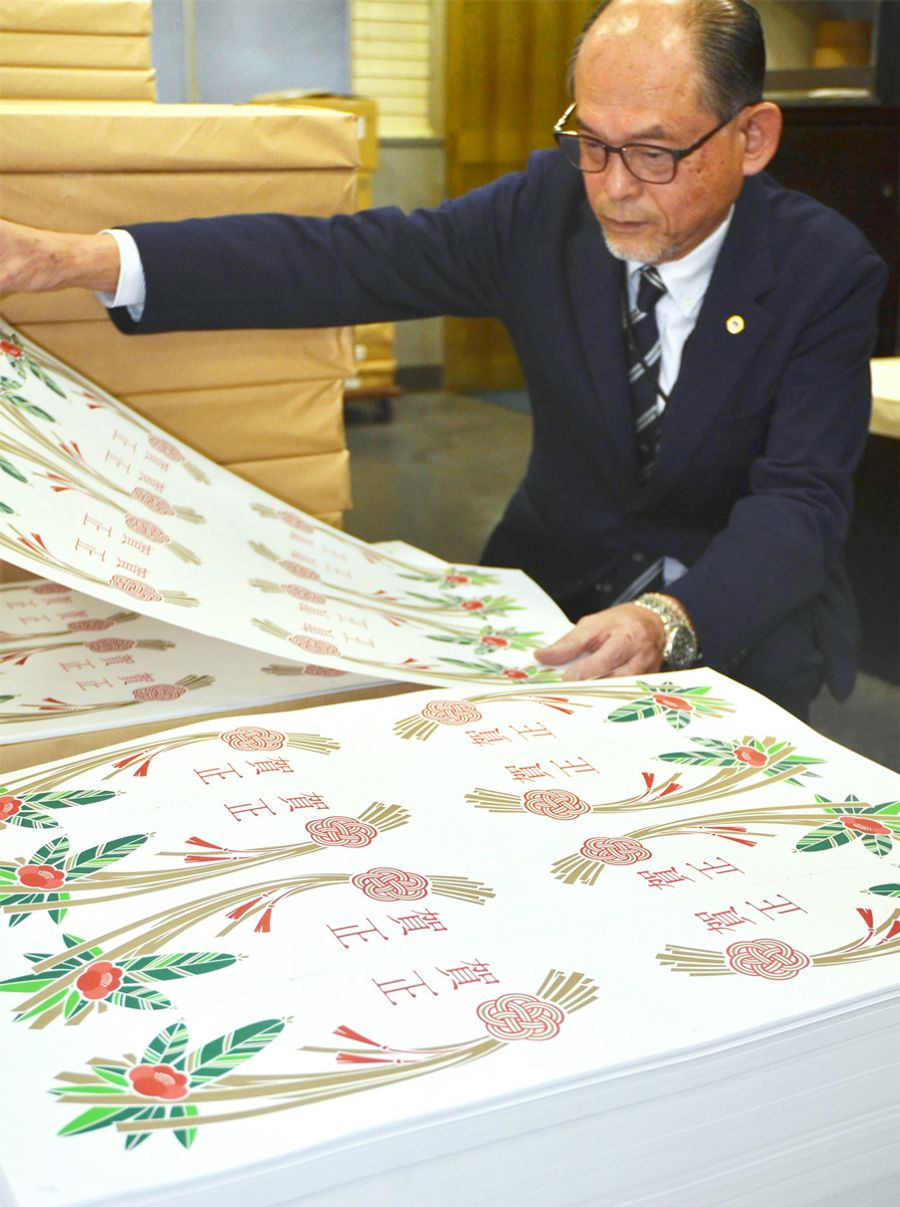 刷り上がった紙の門松を確認する酒井陽典社長(高知市上町3丁目)