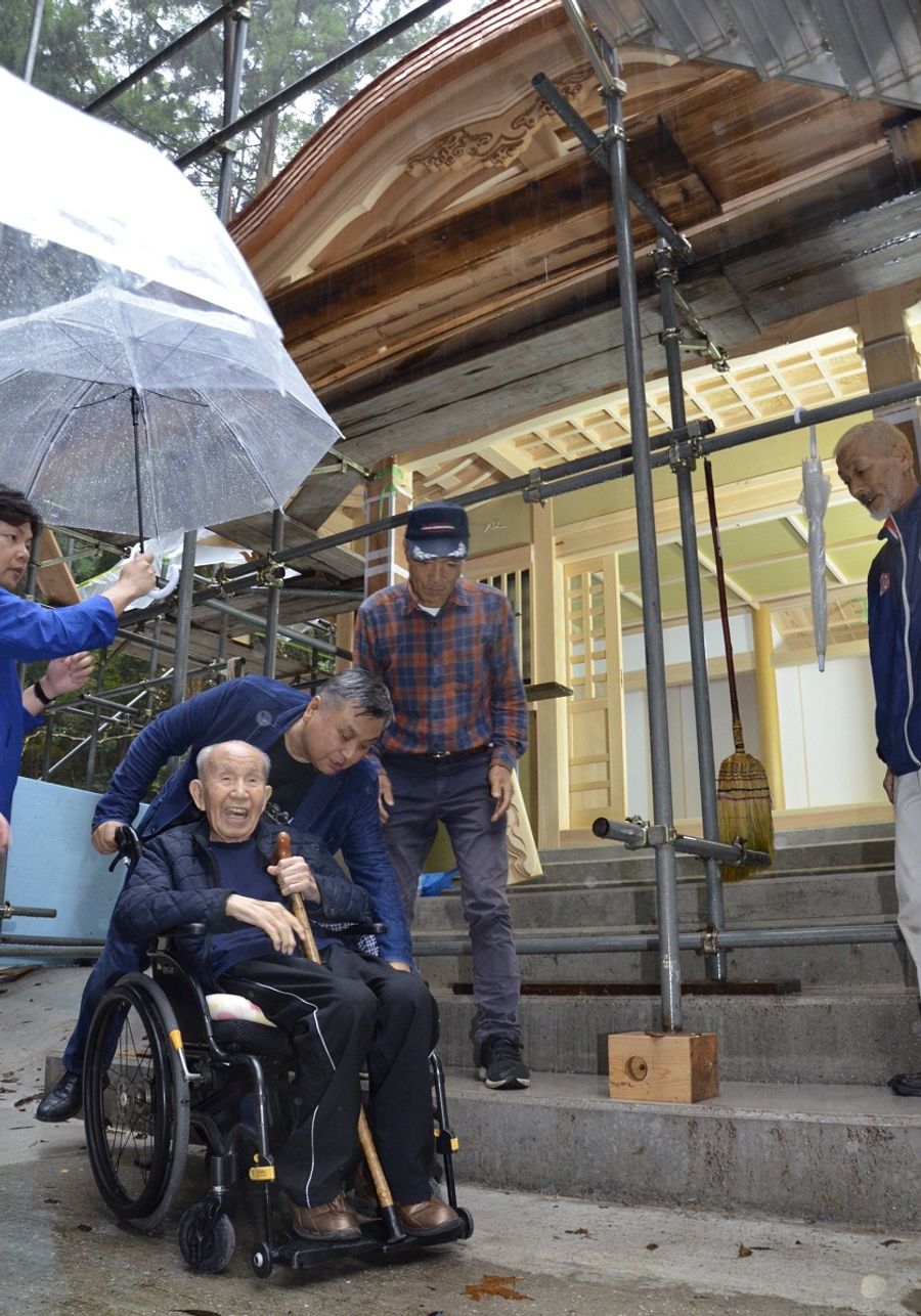 完成形が見えてきた馬之助神社の新社殿と、視察に訪れた宮脇修さん＝手前。長男の修一専務が付き添った（四万十町打井川）