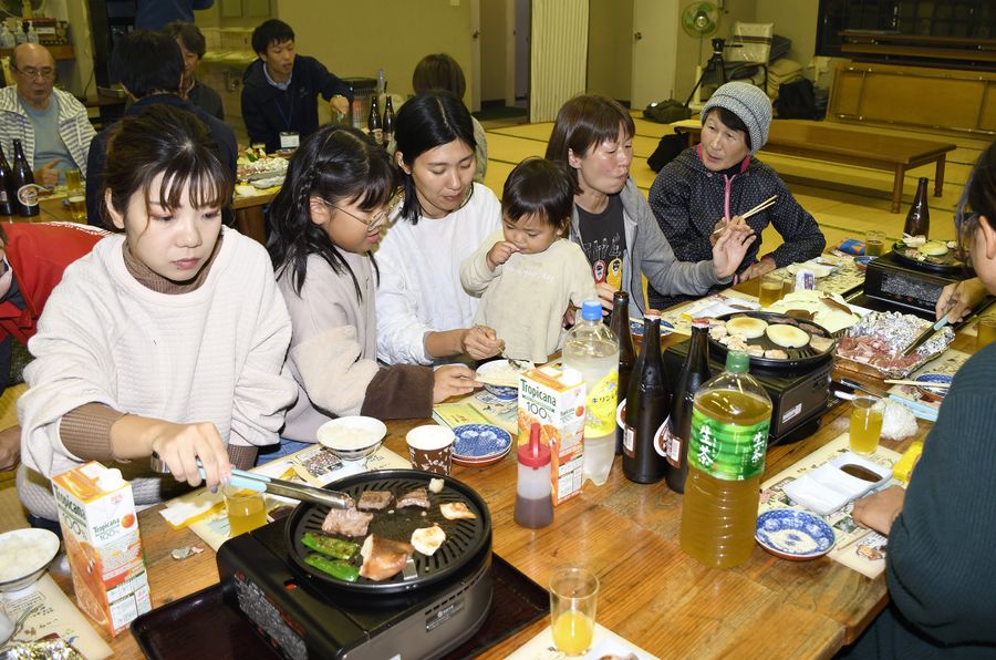 夕食で大川黒牛や土佐はちきん地鶏のバーベキューを楽しむ参加者。住民との会話も弾んだ（写真はいずれも大川村朝谷）