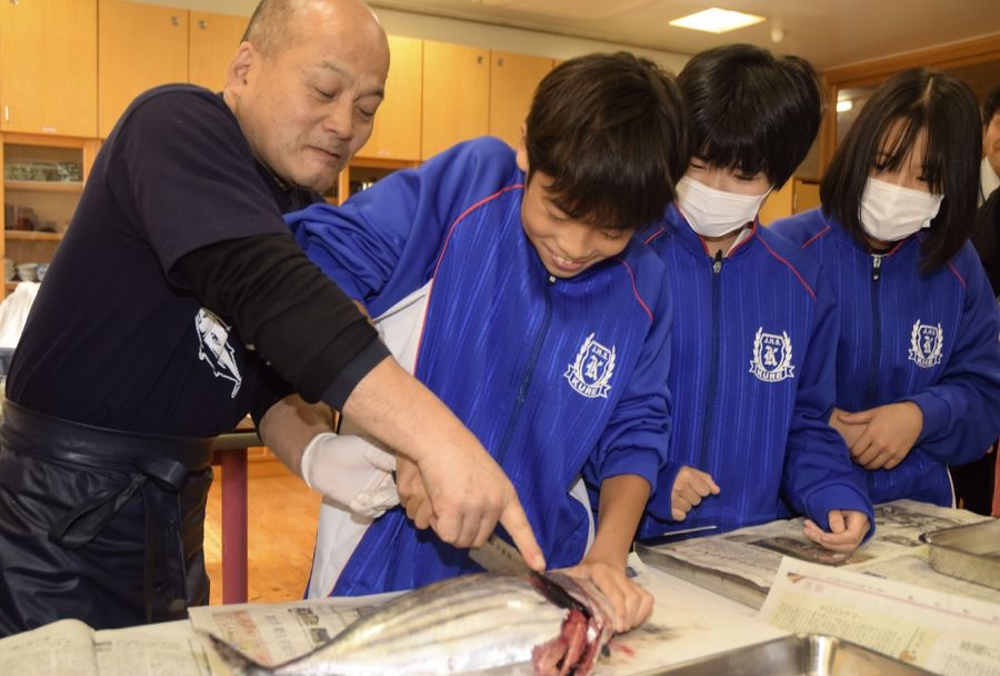 プロの魚屋さんに手ほどきを受けカツオをさばく生徒たち（中土佐町の久礼中学校）