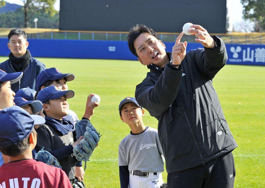 少年野球教室で子どもたちにボールの握りを丁寧に教える藤川球児さん（右端）＝高知市の春野球場