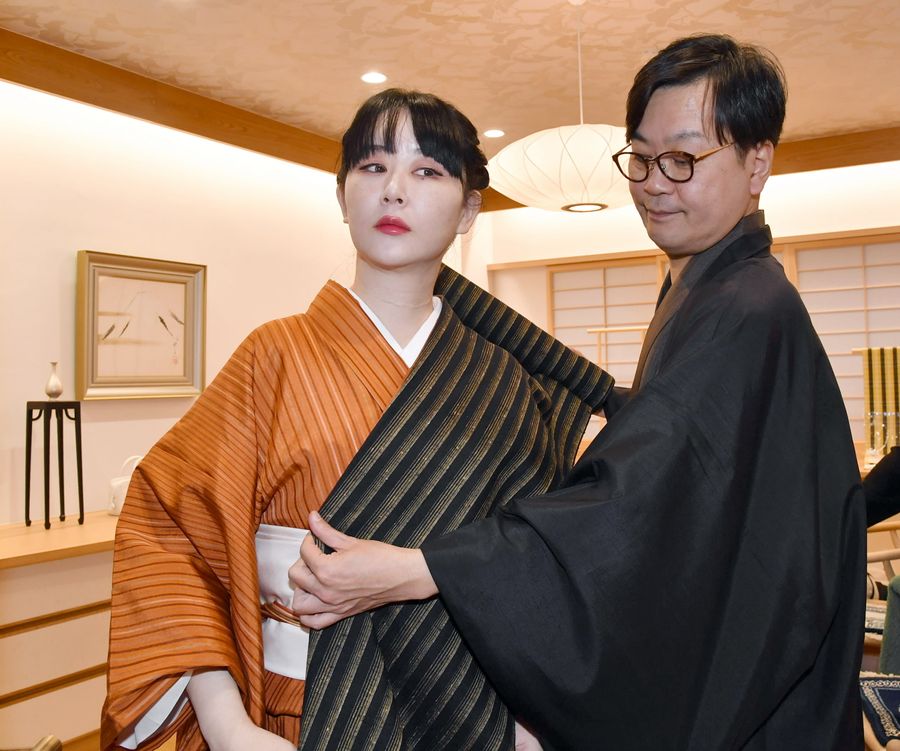 着物を見立てる東村アキコさん。右は店主の美馬勇作さん（高知市永国寺町の「ごふく美馬」＝河本真澄撮影）