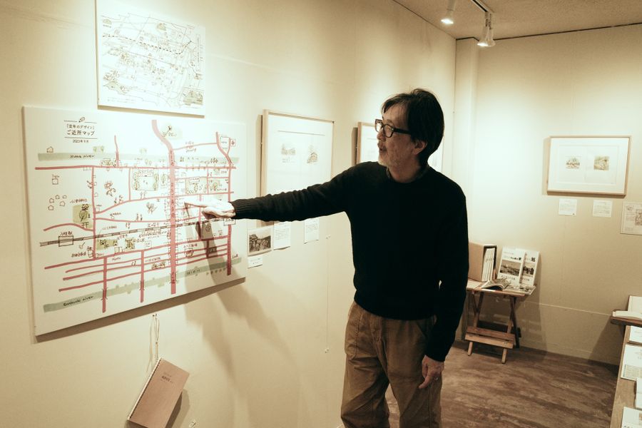 「定年のデザイン」に出てくる店や公園などを記した「ご近所マップ」を説明する筆者の里見和彦さん（高知市越前町２丁目の「十月」）