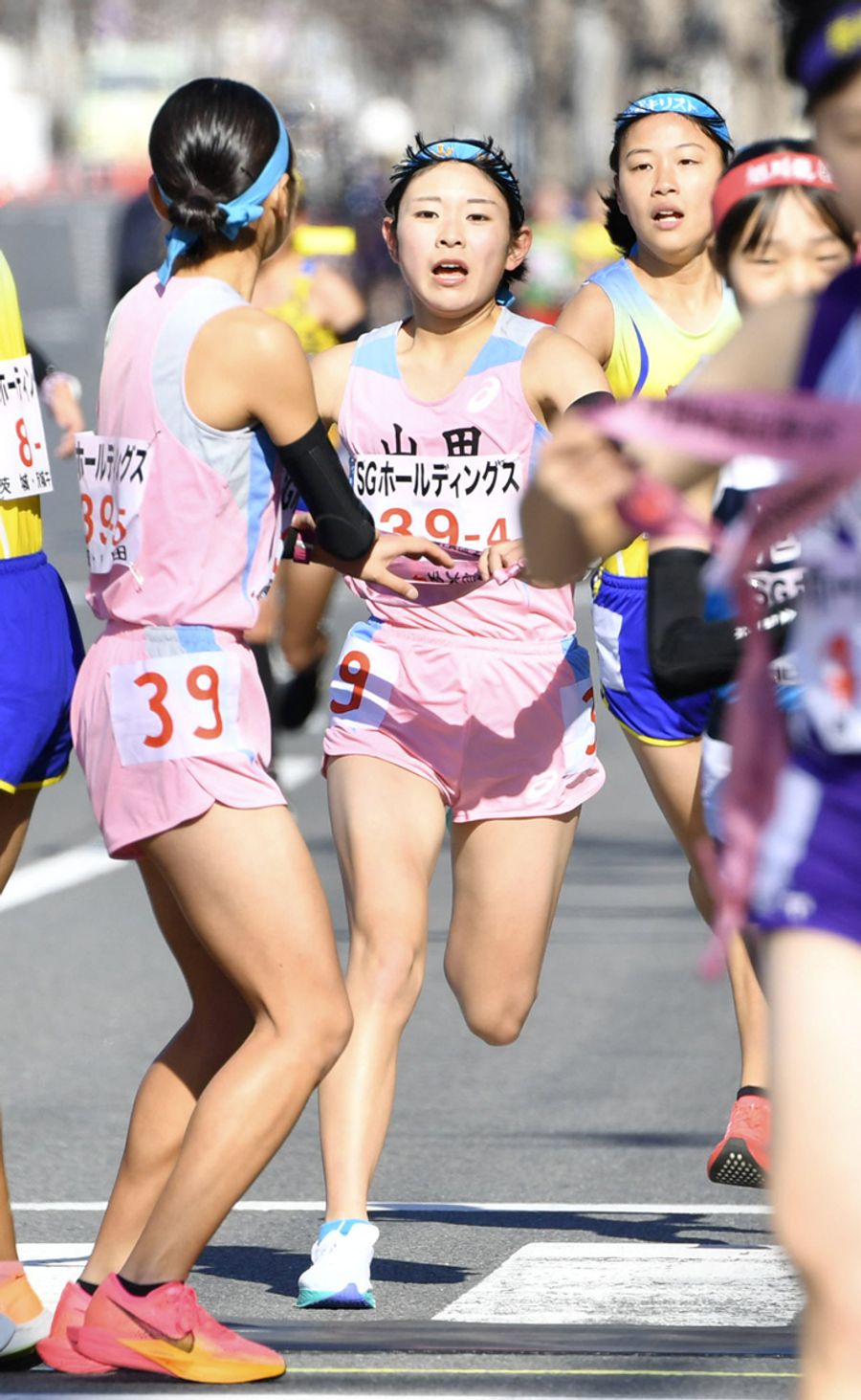 山田の４区清藤奈穂＝右＝から５区安喜梨花に２１位でリレーする（京都市上京区の第４中継所＝河本真澄撮影）