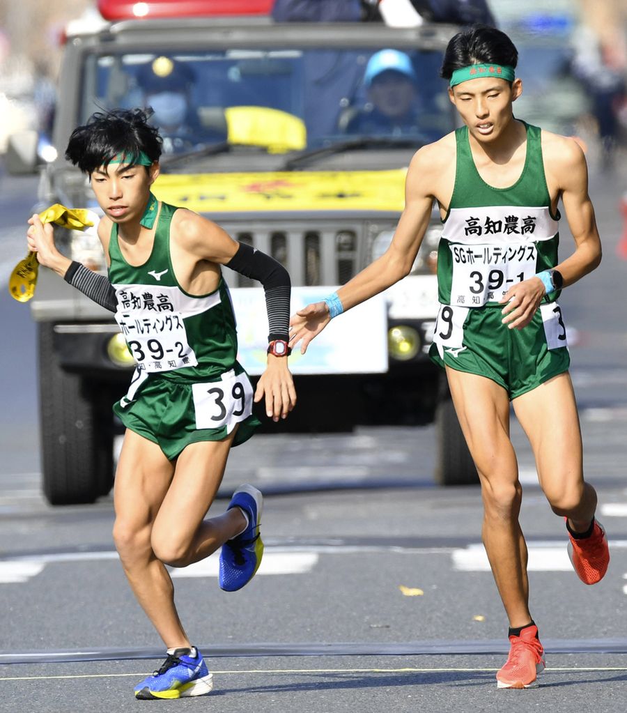 高知農の１区山本聖也＝右＝から２区松田拓真へのリレー（京都市上京区の第１中継所＝河本真澄撮影）