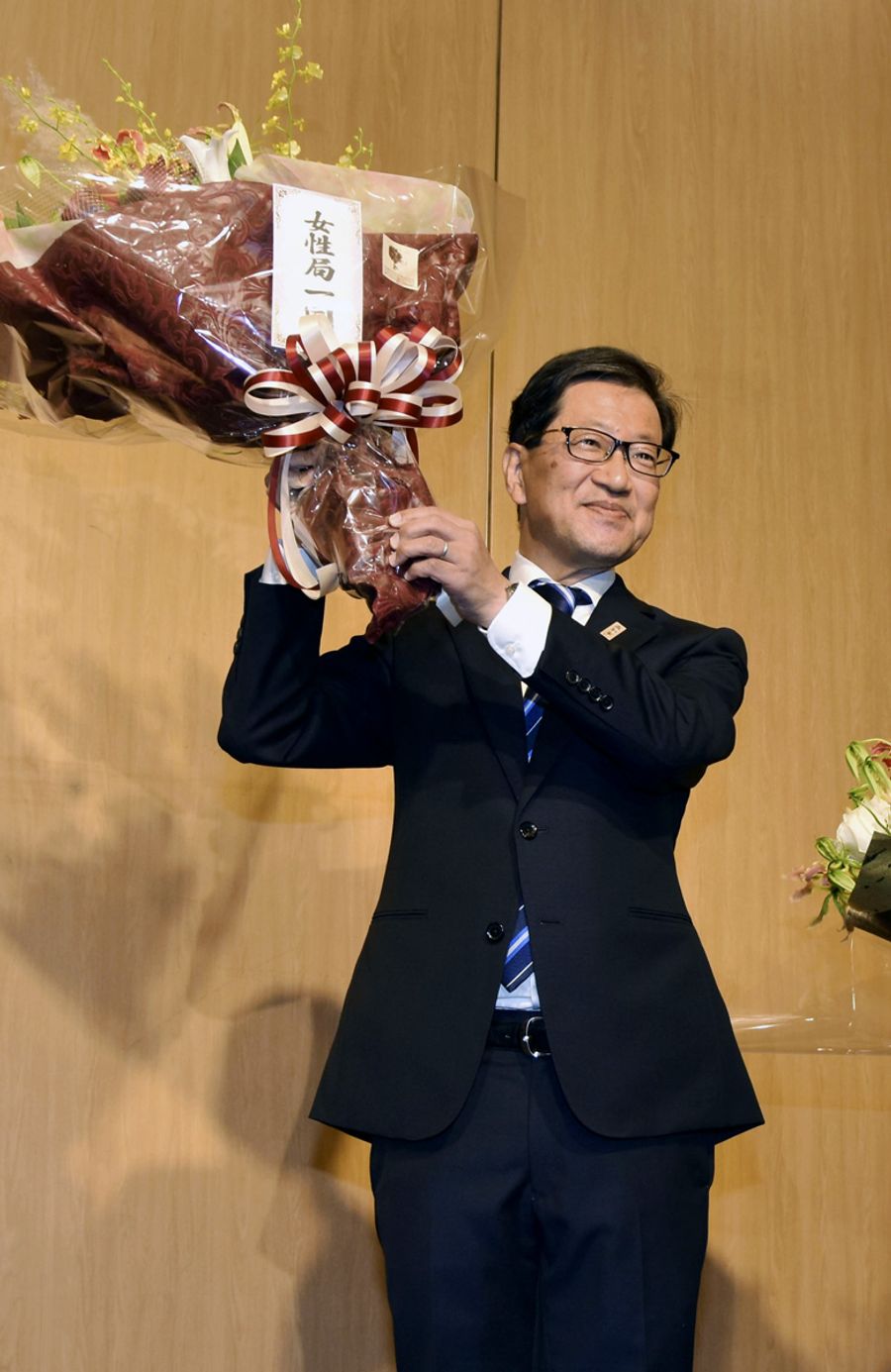 【９位　浜田知事が再選】県知事選で再選を決め、花束を掲げる浜田省司氏（１１月２６日、高知市内）