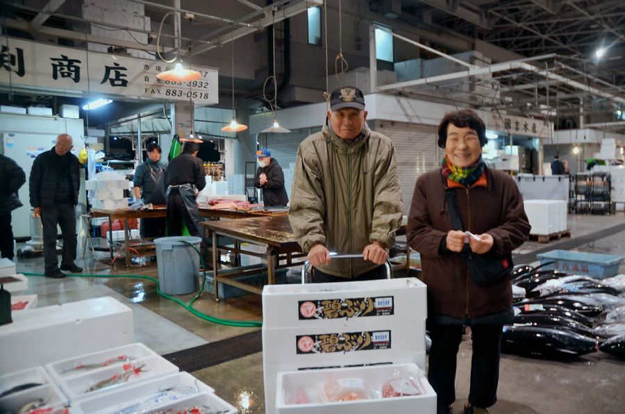 「最後の魚」を仕入れて写真に収まる明坂義和さん（左）夫妻。「ほっとした」と静子さん＝２８日未明、高知市弘化台の市卸売市場