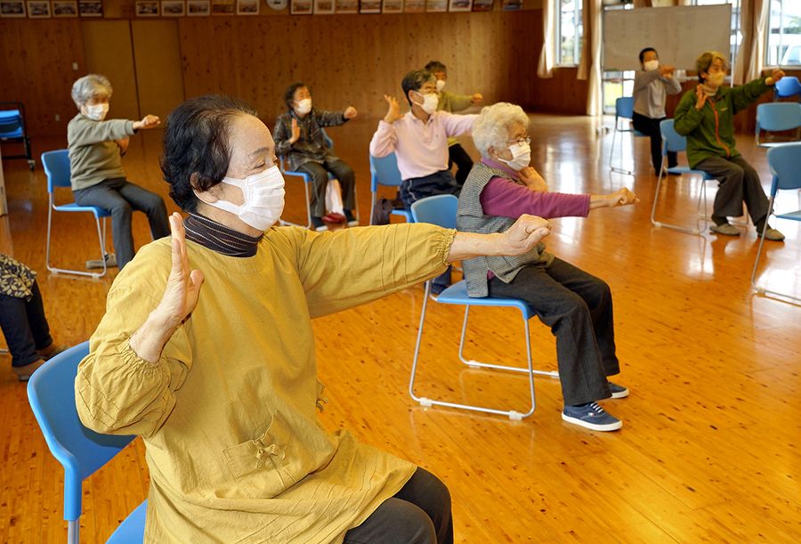 手を握ったり開いたり。頭と体を動かす体操に励む住民たち（写真はいずれも韮生野コミュニティセンター）