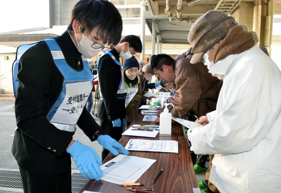 避難所の受付で住民に名前を書いてもらう生徒ら（高知市の愛宕中学校）