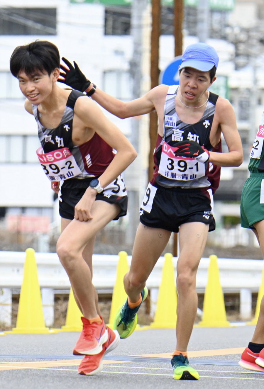 高知の１区高石樹＝右＝から２区岩下幾海へのたすきリレー（広島市西区の第１中継所）