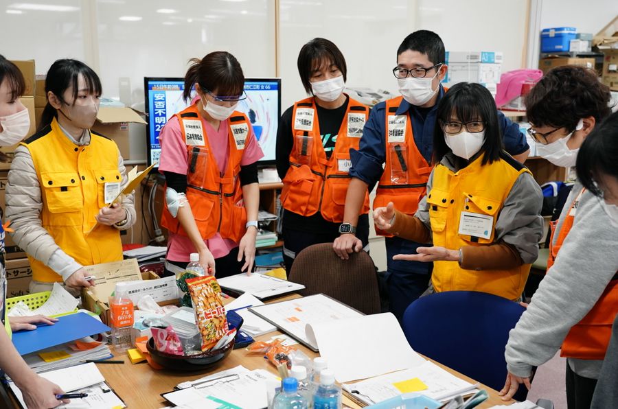黄色のベスト姿が高知県の保健師ら。他県から派遣されたナースらと情報交換する