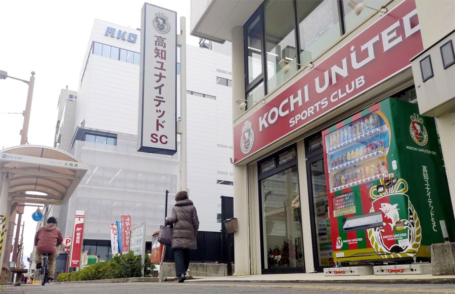 高知市の電車通り沿いに移転した高知ユナイテッドＳＣの事務所。入り口の自動販売機もエンブレム入りのチーム仕様だ（同市本町３丁目）