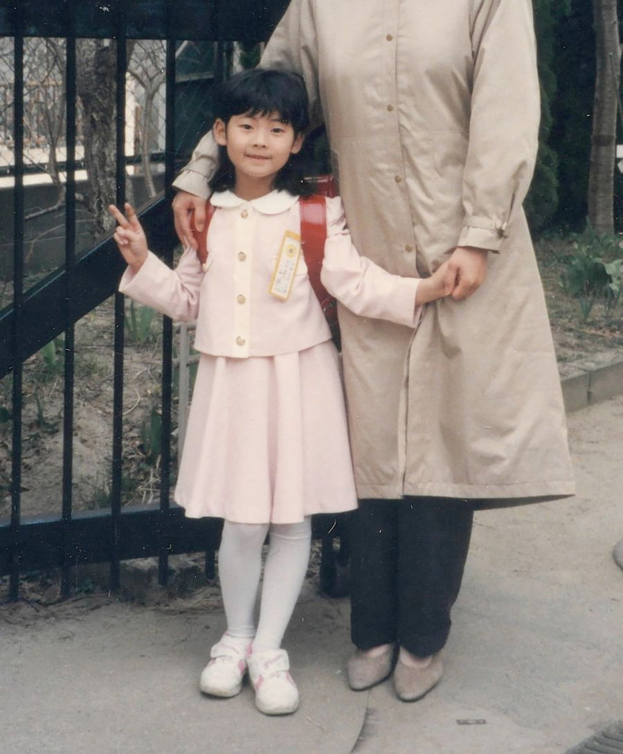 子ども時代の勝又栄政さん。小学校入学式にはピンクのスーツを着て出席した（提供写真）