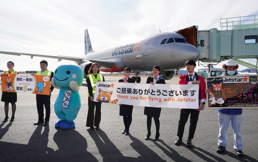 横断幕を掲げて高知―成田線の就航５年を祝う関係者ら（高知龍馬空港）