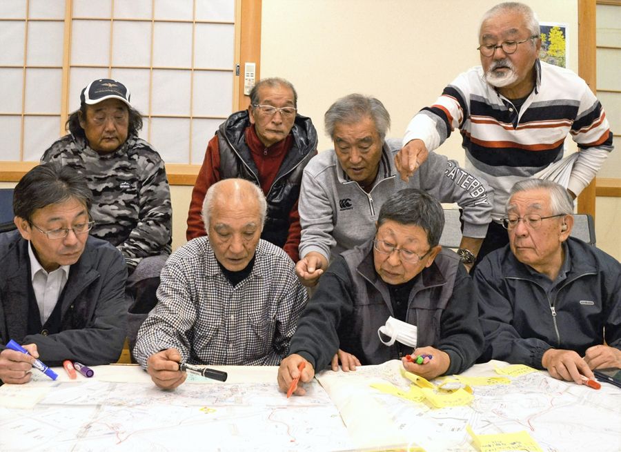 地図に付箋を貼って要支援者らの情報をまとめていく「あったか男塾」のメンバー（奈半利町乙の法恩寺集会所）