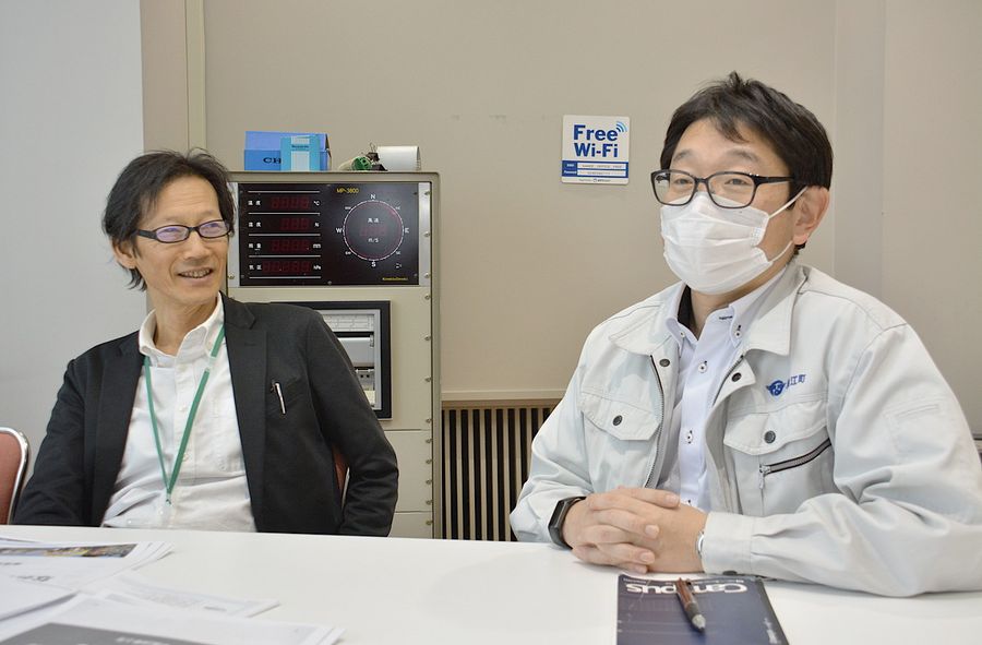 同僚と仕事の打ち合わせをする吉本幸弘さん＝左（浪江町役場）