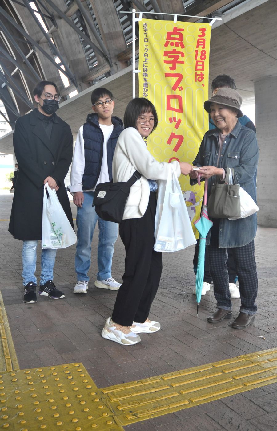 点字ブロックの重要性を訴え、ティッシュを配る盲学校卒業生ら（高知市のＪＲ高知駅前）