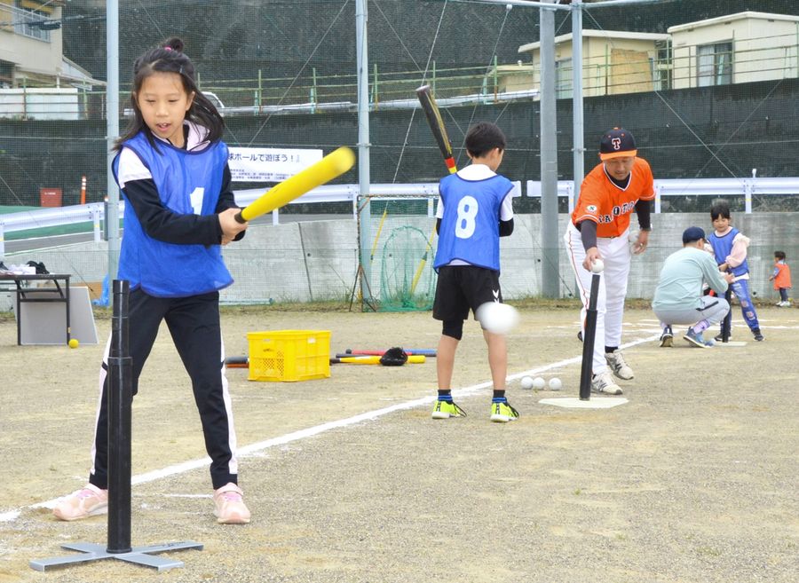 社会人チームの部員からボールの打ち方を教わる子どもたち(田野町の田野中学校)