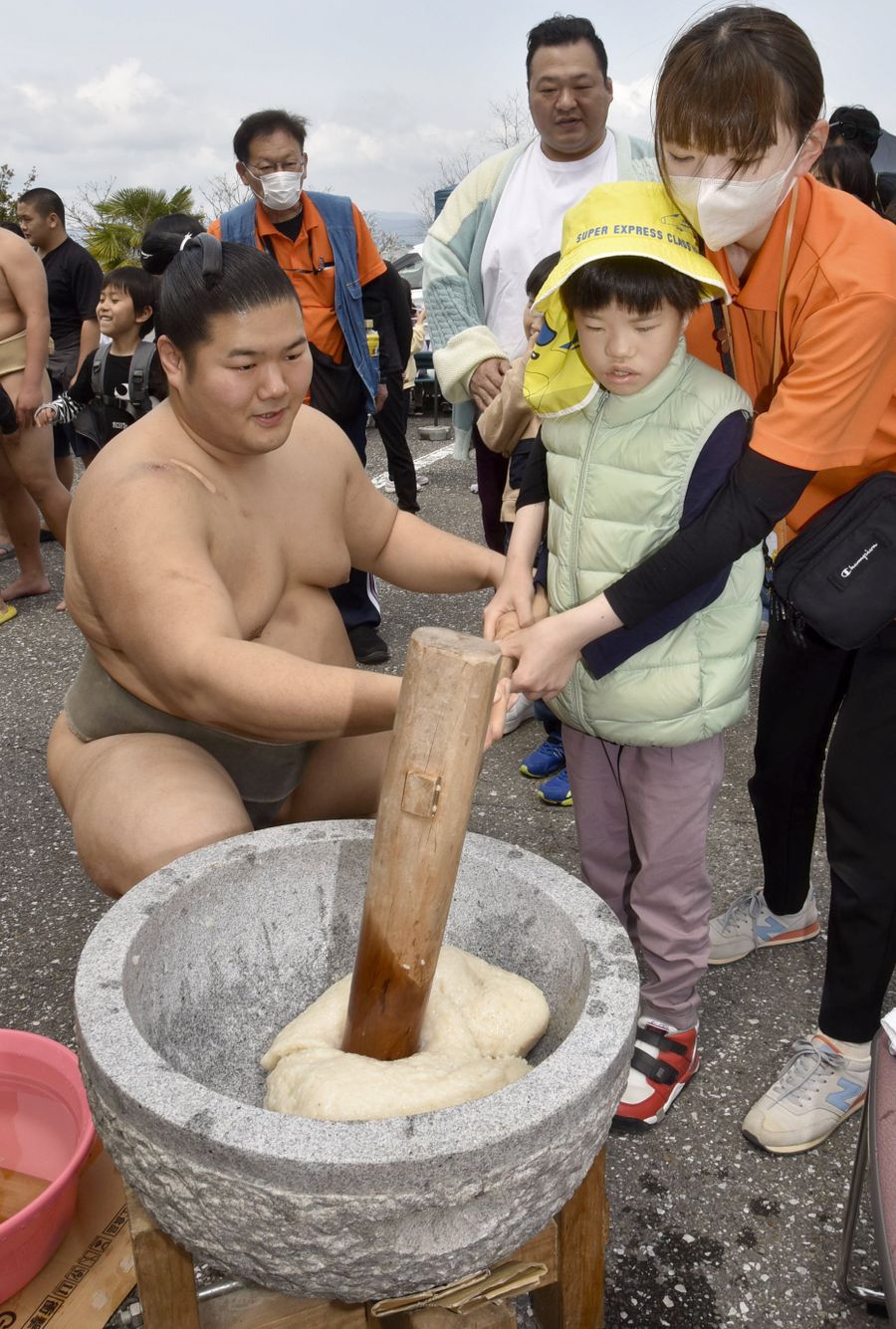 瀬戸豊に優しく支えられてぺったんぺったんお餅つき。奥で見守るのは豊ノ島さん(南国市田村乙の市立日章福祉交流センター)