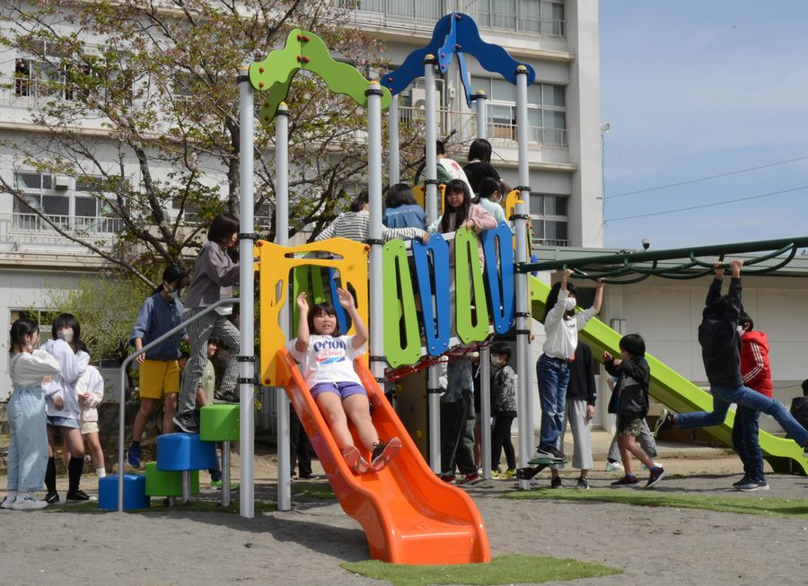 卒業生や保護者らが寄贈した複合遊具で遊ぶ子どもたち（高知市高見町の潮江南小学校）
