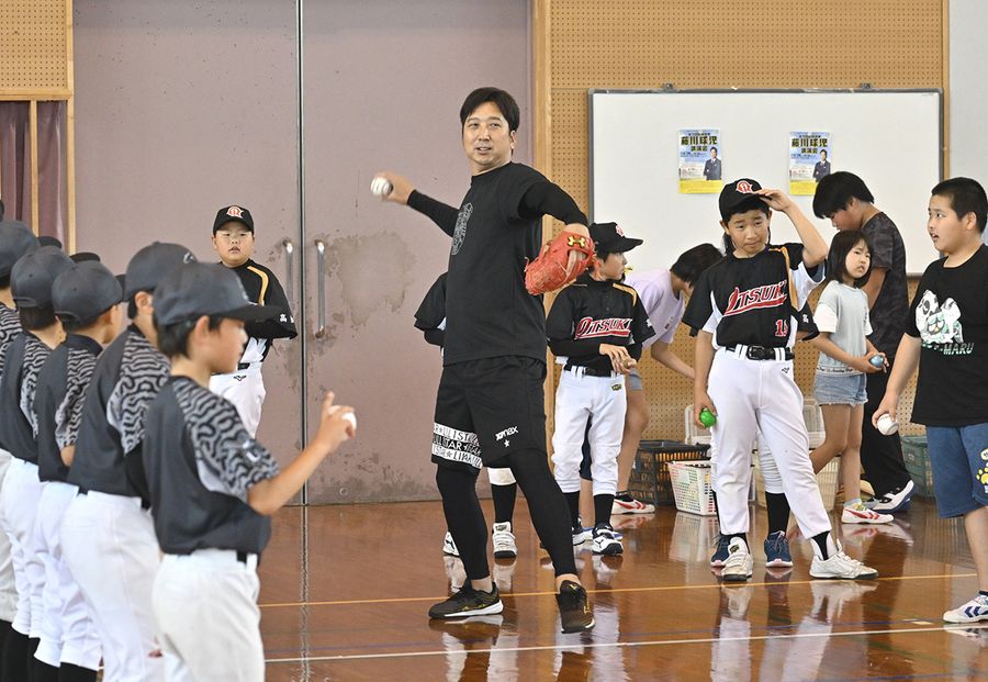児童にボールの投げ方を伝える藤川球児さん　（土佐清水市清水の市民体育館）