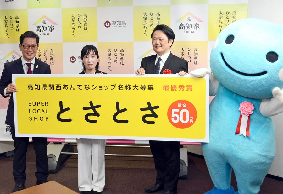 浜田知事と店名のパネルを持ち、記念撮影する（右から）諏訪野大さんと伊賀未来さん＝県庁