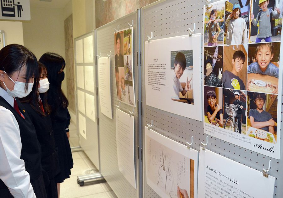 交通事故で亡くなった子どもたちの写真パネルを見学する中学生（高知市のオーテピア）
