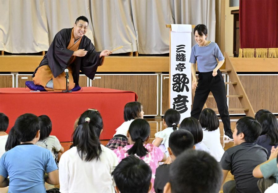 落語で子どもたちを楽しませる三遊亭歌彦さん（左奥）＝土佐清水市の三崎小学校