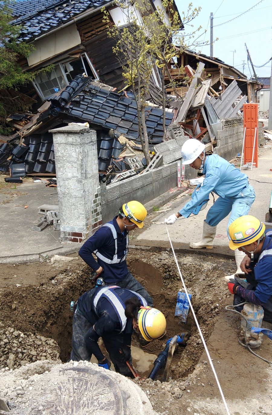 倒壊家屋が連なるエリアで地面を掘り、管をつないでまた埋める。地道な作業が水を届ける(4月、石川県珠洲市正院町)