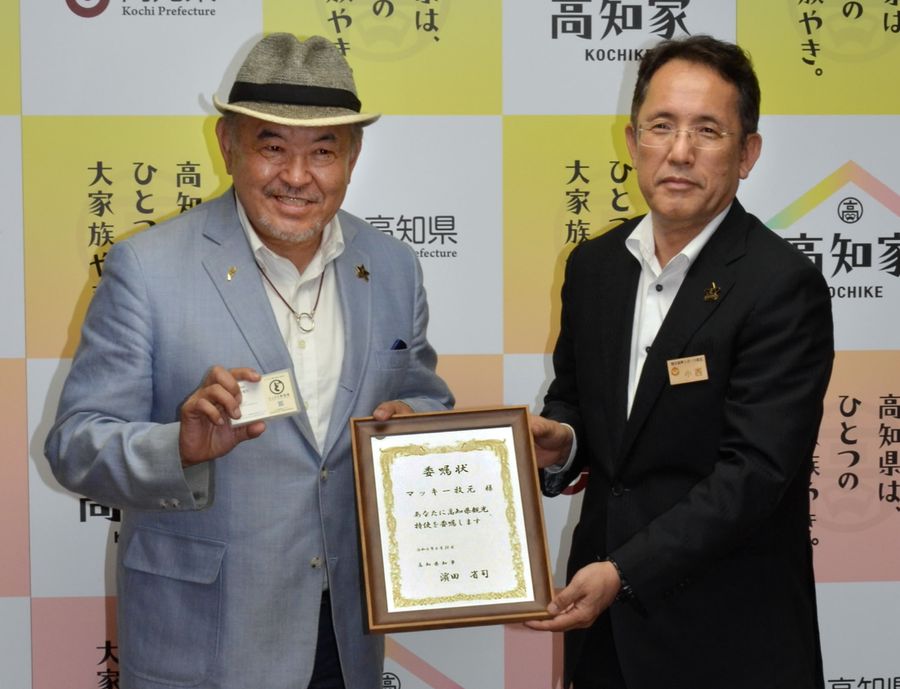 委嘱状を受け取るマッキー牧元さん=左(高知県庁)