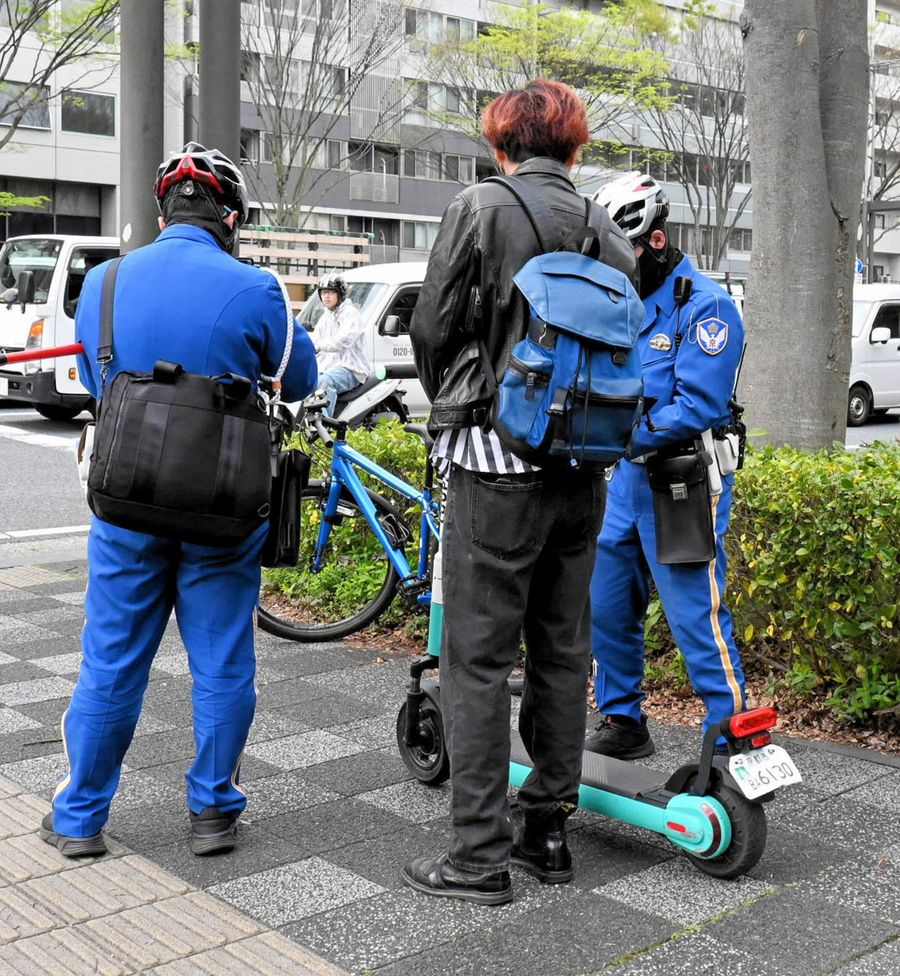 御池通で電動キックボードの交通違反を取り締まる警察官（京都市中京区）