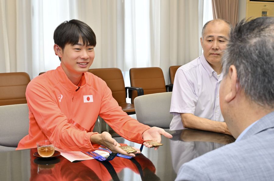 土佐清水市の程岡庸市長らにメダルを見せる岡田泰尚選手（同市役所）