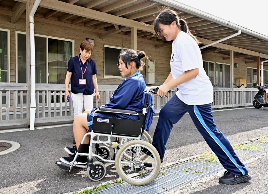 指導を受けながら車いすを押す清水高生（土佐清水市浜町）