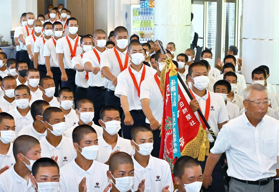 馬淵史郎監督に続き、高知大会優勝旗を手に元気よく入場する平尾成歩主将ら明徳ナイン（写真はいずれも須崎市浦ノ内下中山の明徳中高＝新田祐也撮影）